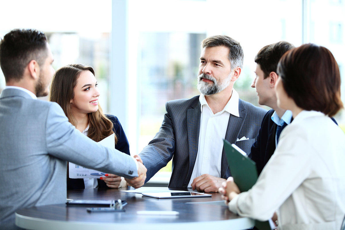Business team shaking hands across a meeting table